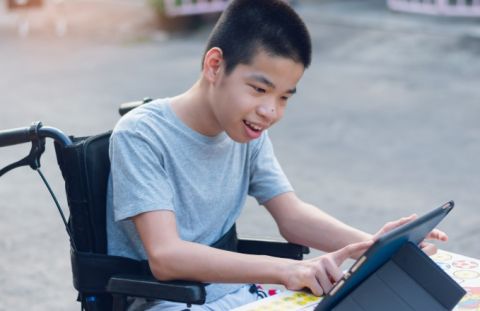 Boy in wheelchair touching a screen