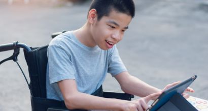 Boy in wheelchair touching a screen